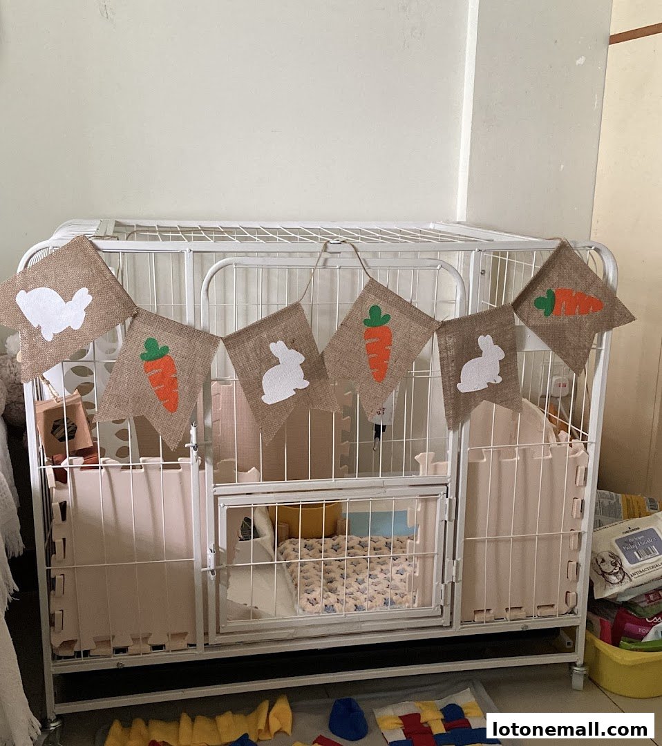 A pet cage decorated with a burlap banner featuring bunnies and carrots.