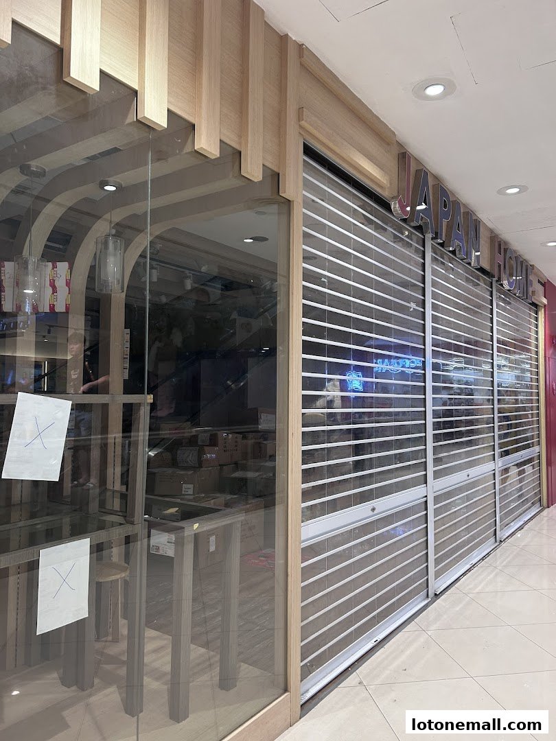 The exterior of the Japan Home shop with its roller shutters down.