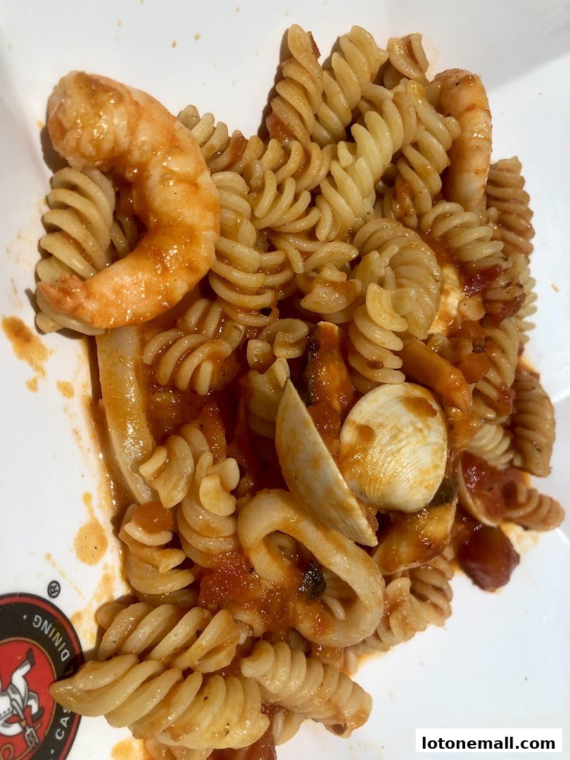 A close-up shot of fusilli pasta with seafood in a tomato sauce.