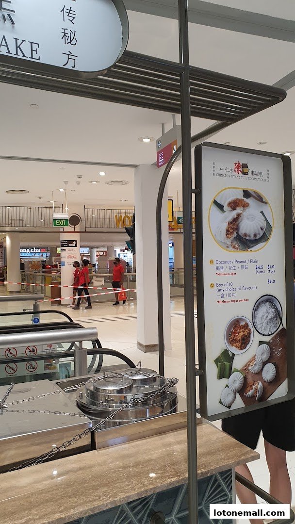 A menu board displays Tutu Coconut Cake with prices and flavors, with a food cart in the foreground.