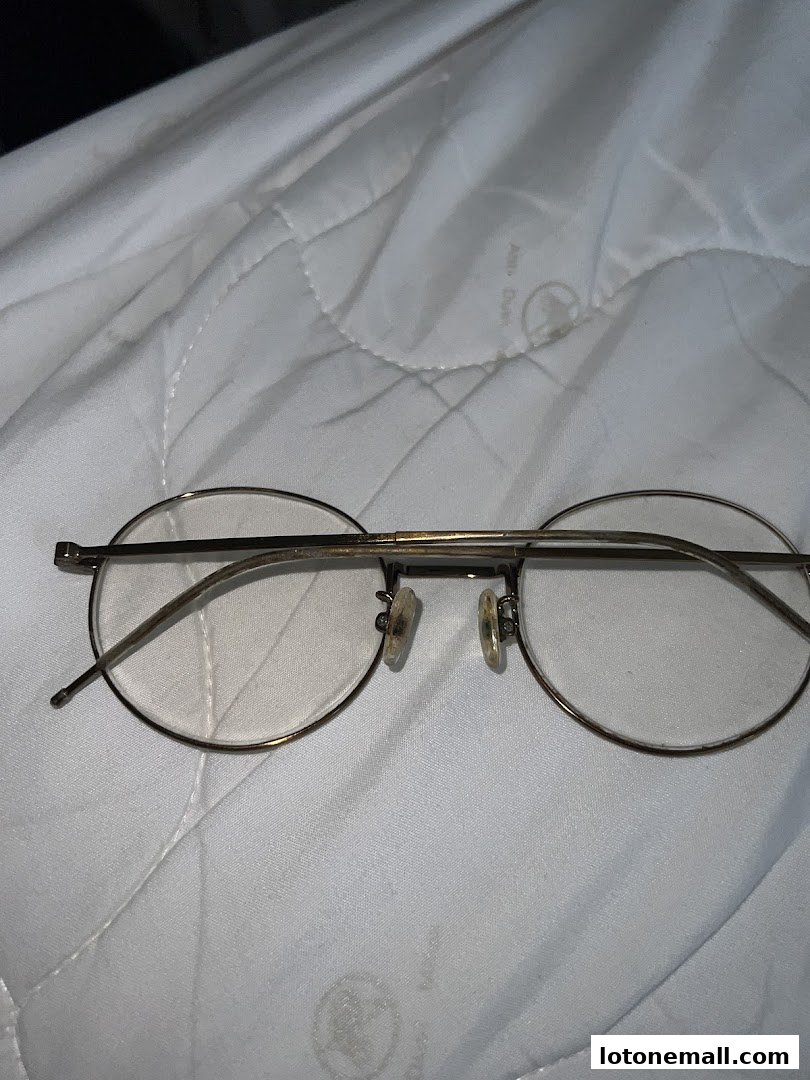 A close-up shot of round, thin-rimmed eyeglasses with clear lenses.