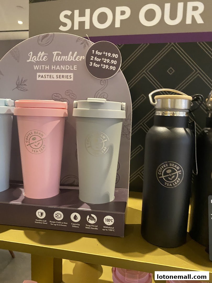 Display of Coffee Bean Tea Leaf tumblers and water bottles with pricing.