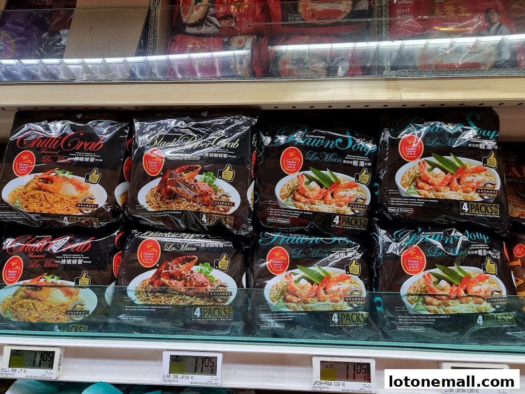 A shelf display of various flavors of instant noodles, including Chilli Crab and Prawn Soup.