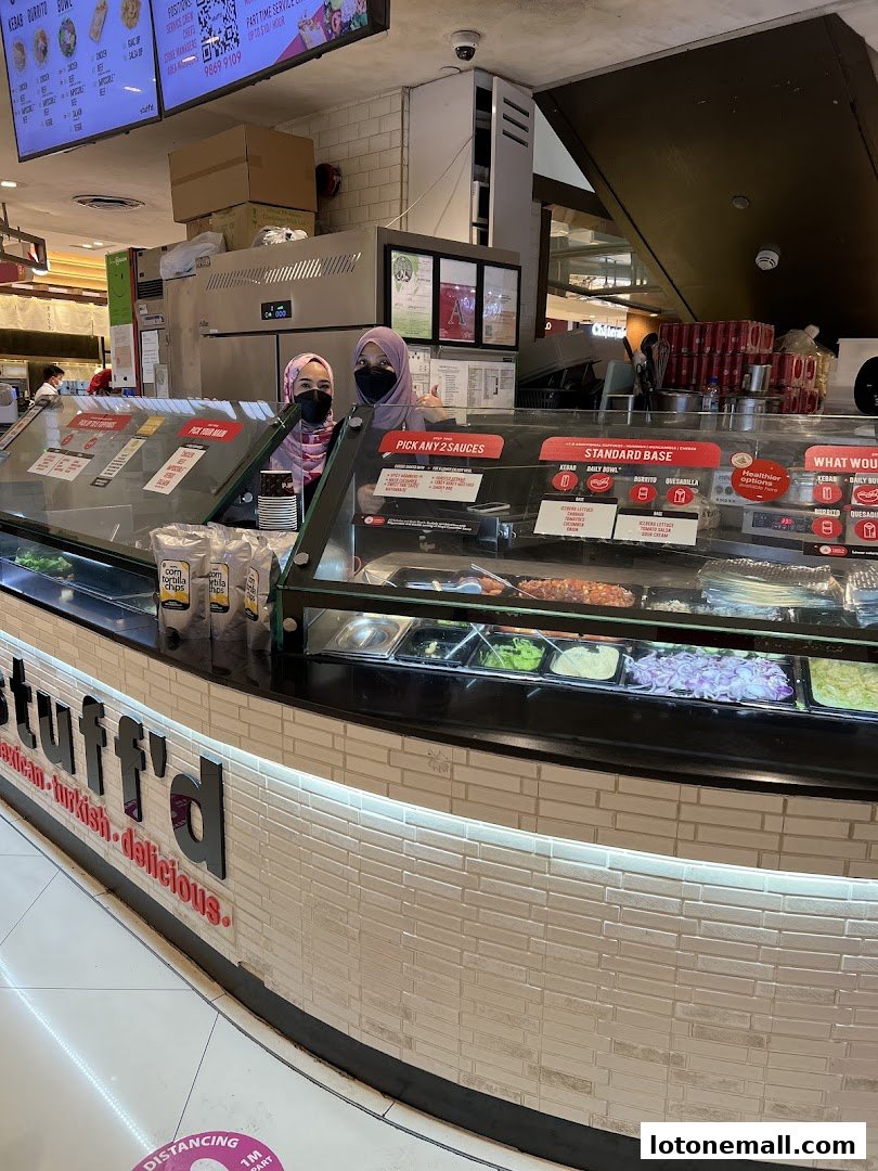 Two staff members behind a food counter at Stuff'd, a Mexican, Turkish, and delicious food shop.