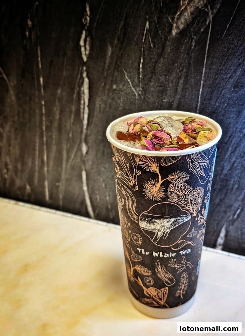 A cup of bubble tea with dried flowers and ice on top, from The Whale Tea.