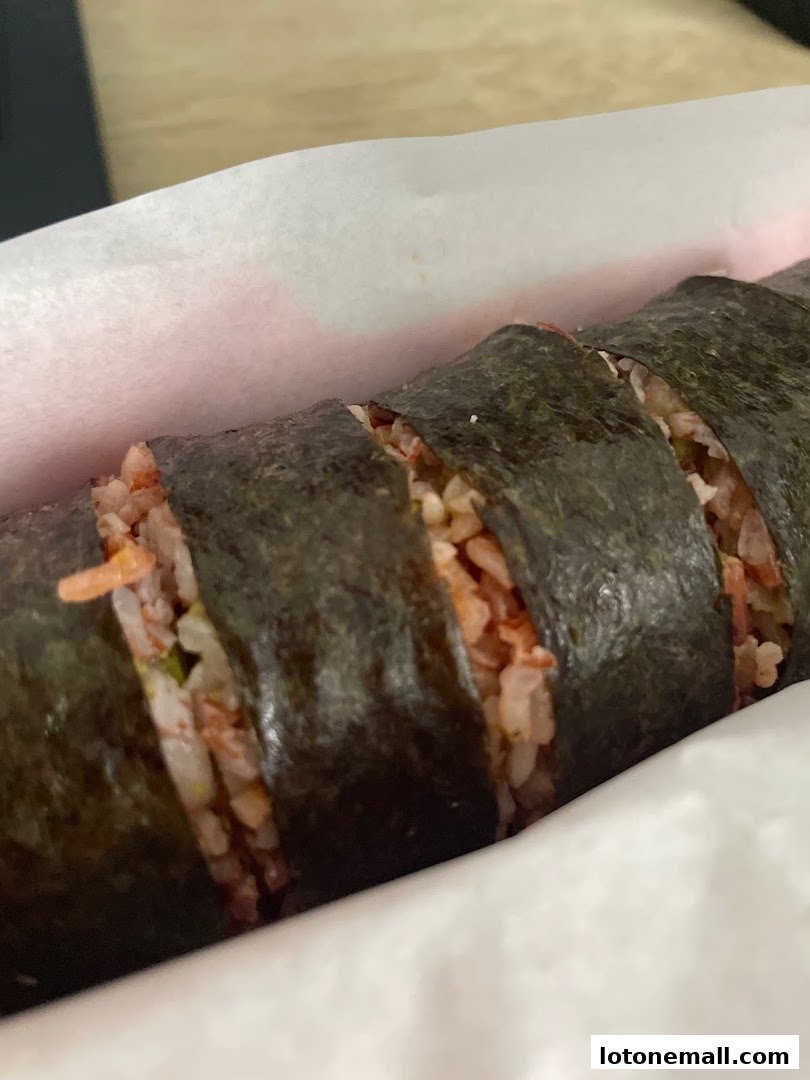 A close-up shot of a sliced sushi roll with visible rice and filling.