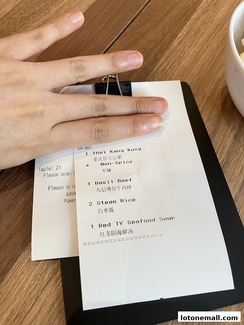 A receipt from Sanook Kitchen showing a table number and food orders.