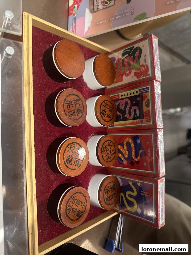 A display of tea tins with wooden lids and decorative boxes with snake motifs.