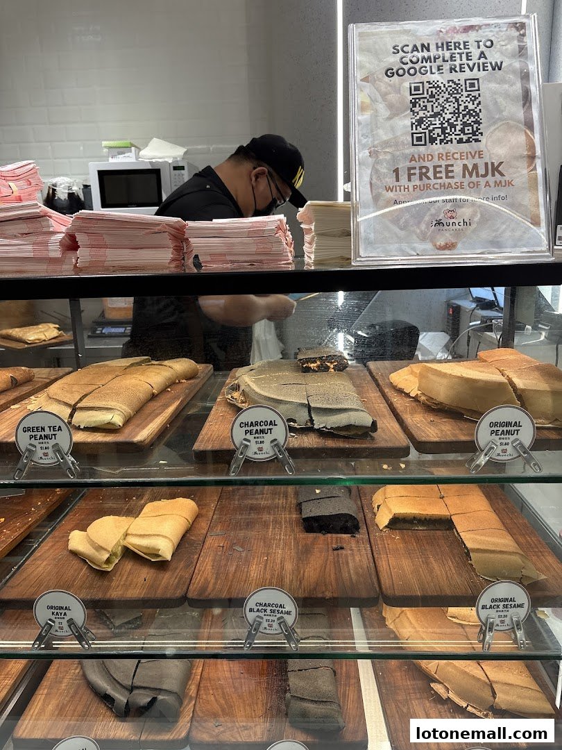 A display case filled with various flavors of pancakes, with a staff member in the background.