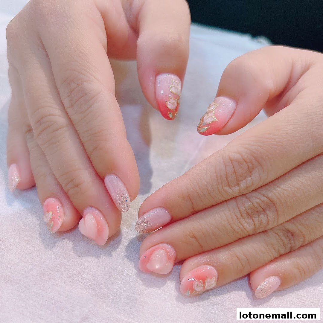 Close-up of hands with beautifully decorated nails featuring pink, white, and gold floral designs.