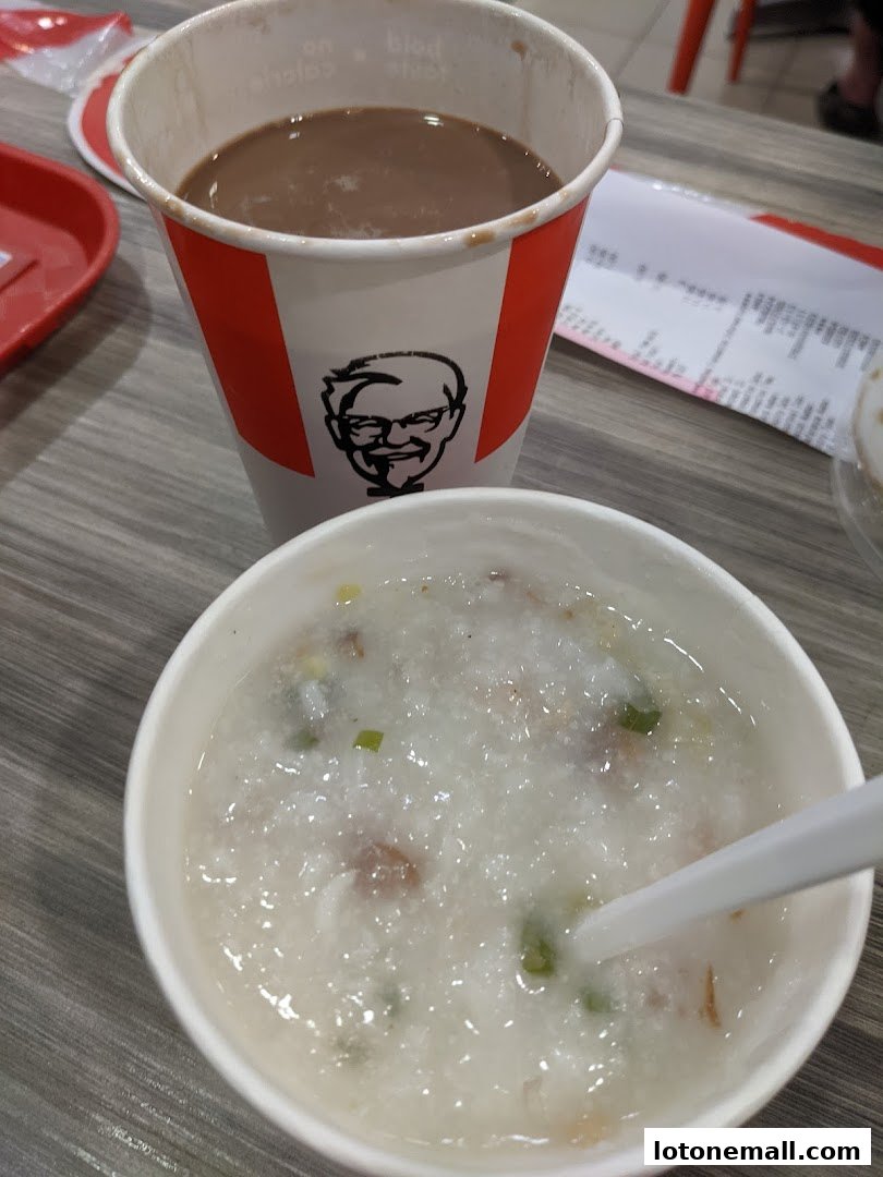 A close-up of KFC congee and a hot beverage in a branded cup.