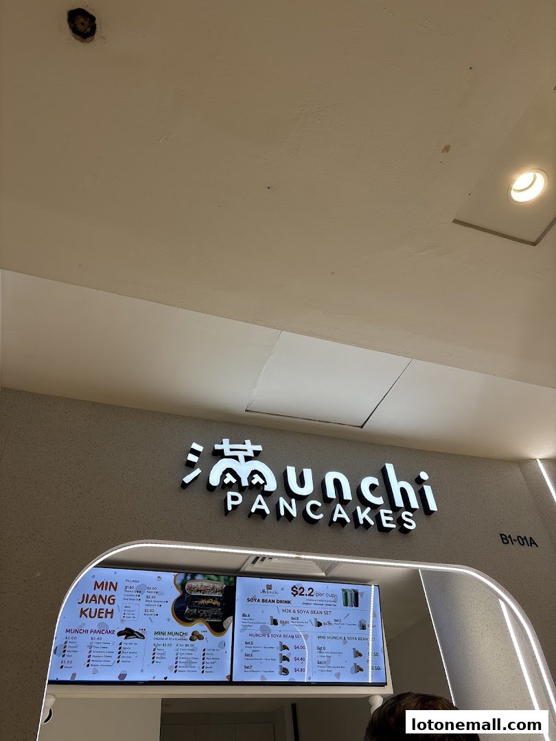 A digital menu board displaying various pancake and drink options at Munchi Pancakes.