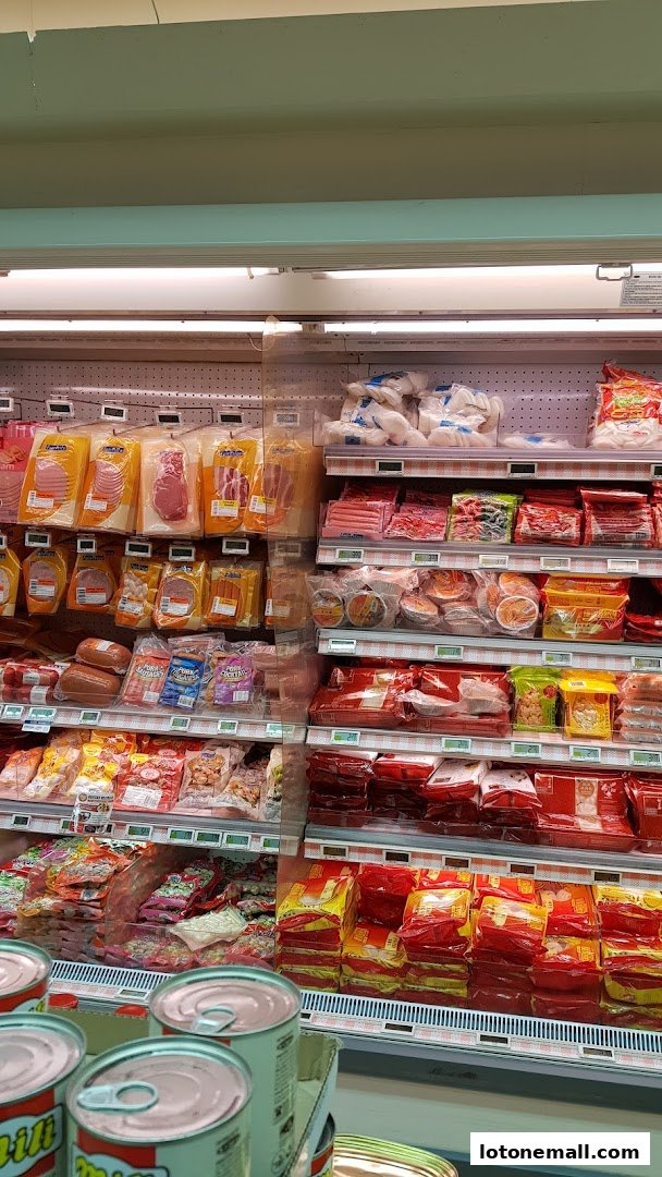 A wide selection of packaged meats and canned goods displayed on refrigerated shelves.