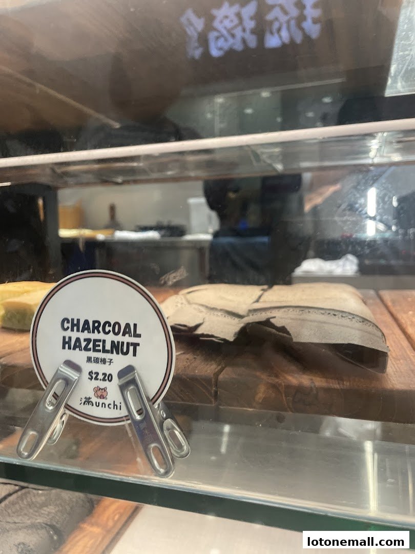 A close-up of a charcoal hazelnut pancake with a price tag at Munchi Pancakes.