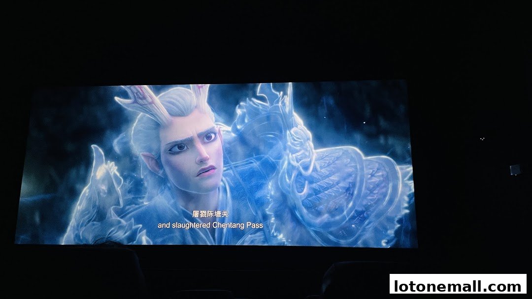 A movie scene displayed on a cinema screen featuring a character with white hair and antlers.