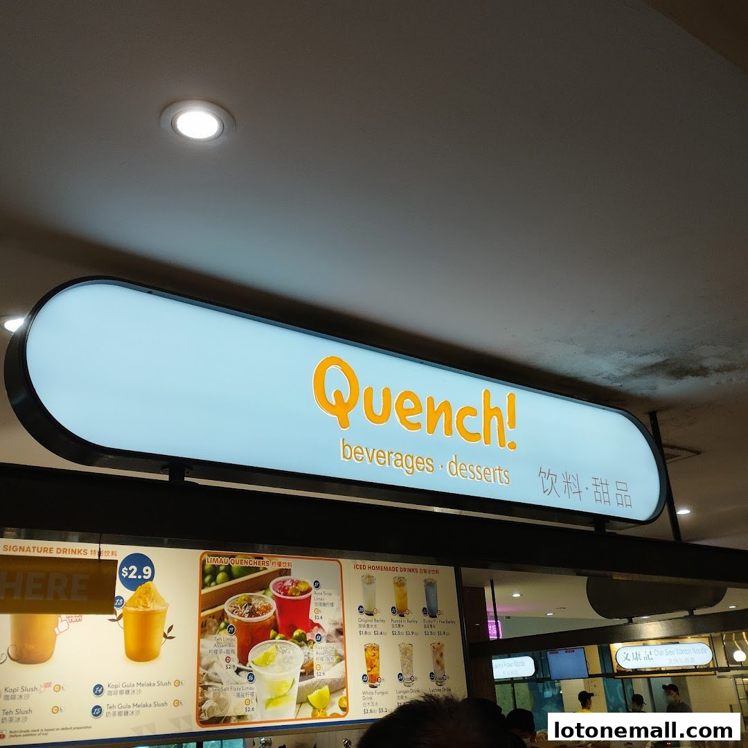 A brightly lit sign for 'Quench!' beverages and desserts with a menu displayed below.