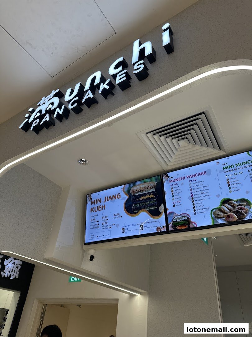 A digital menu board displaying various pancake and kueh options with prices.