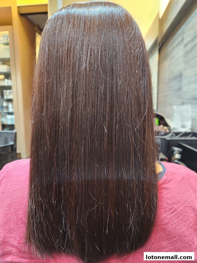 A person's long, straight, dark brown hair after a salon treatment.