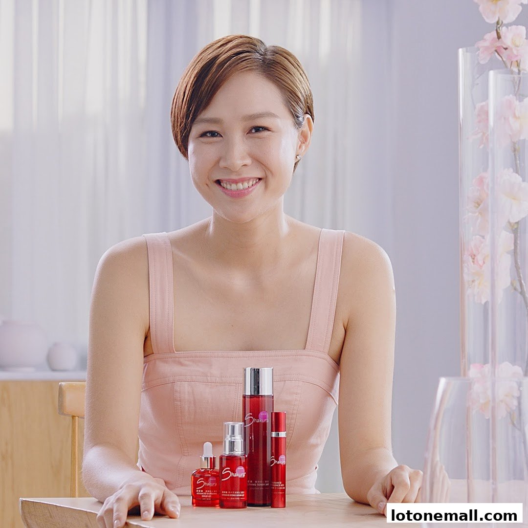 A smiling woman with short hair poses with Shakura beauty products.