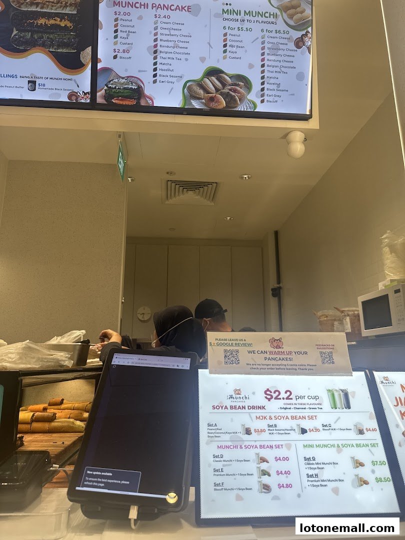 A menu board displaying various pancake and soya bean set options at Munchi Pancakes.