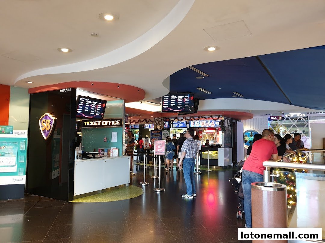 People queuing at the ticket office and concession stands of a cinema.
