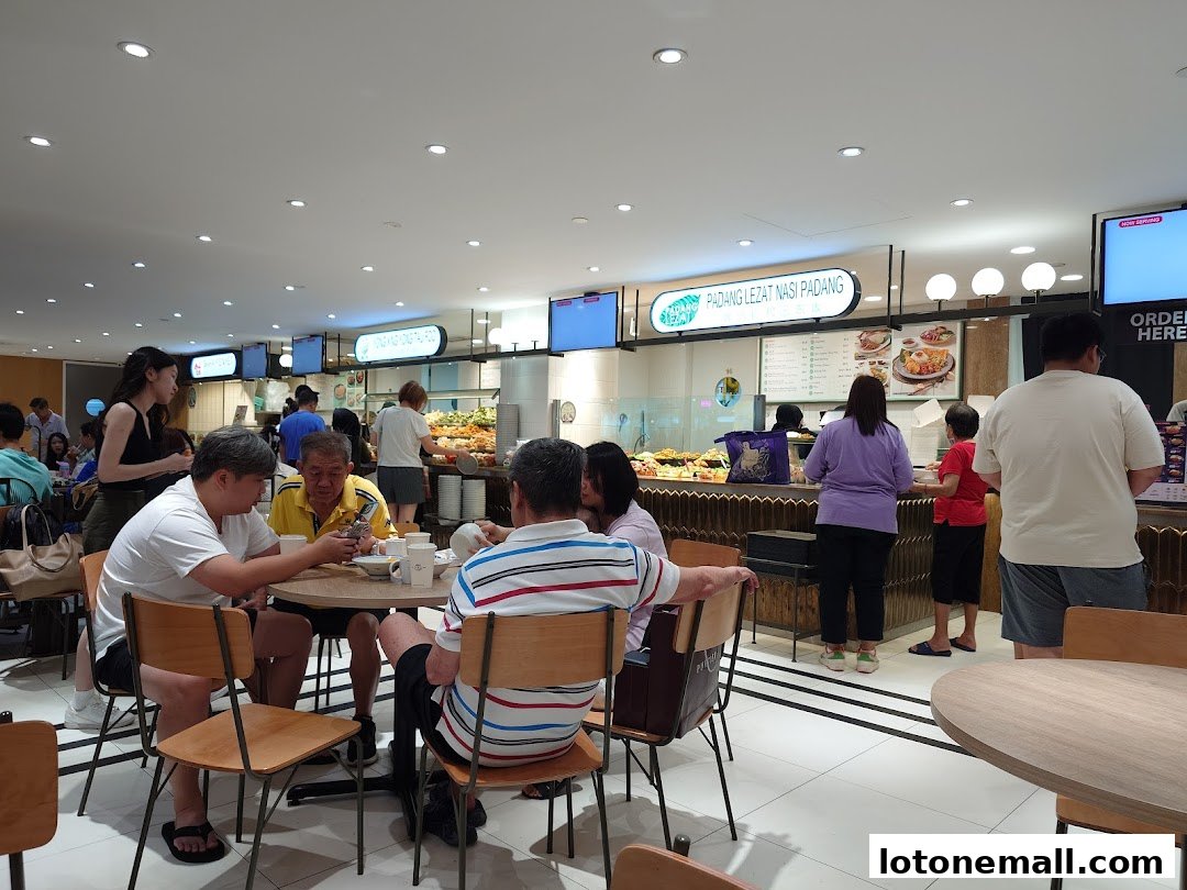 People dining and queuing at a busy food court with various food stalls.