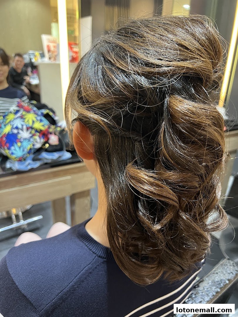 A woman with a stylish updo hairstyle, showcasing curls and volume.