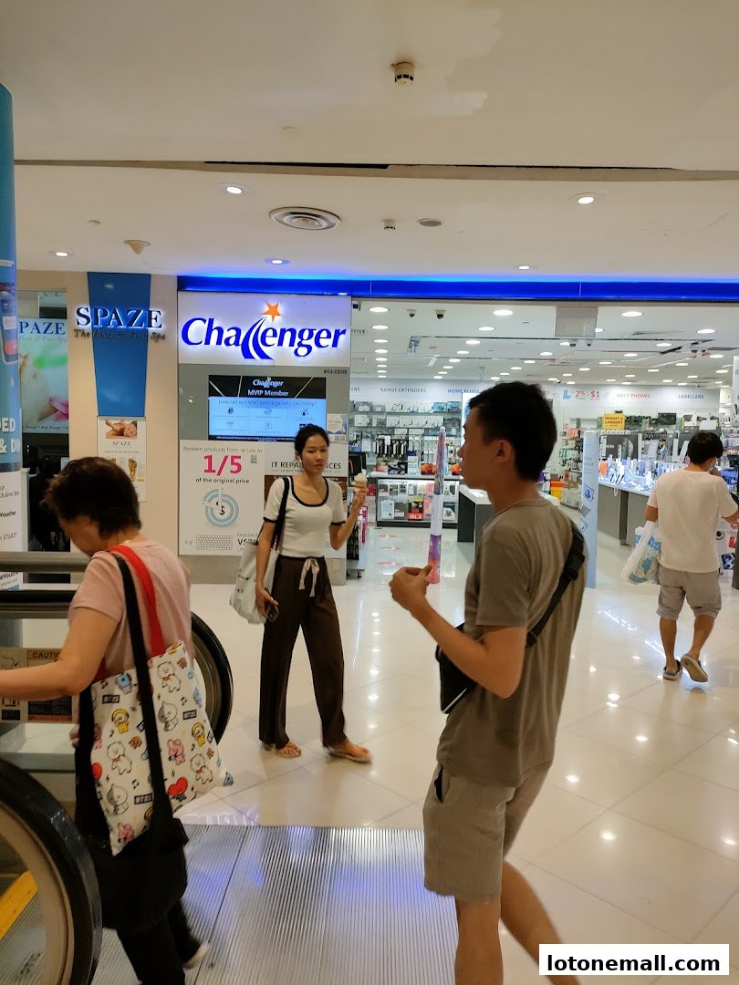 People walking past a Challenger electronics store and a Spaze spa in a shopping mall.