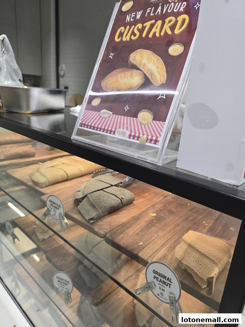 A display case filled with various types of pancakes and a sign advertising a new custard flavor.