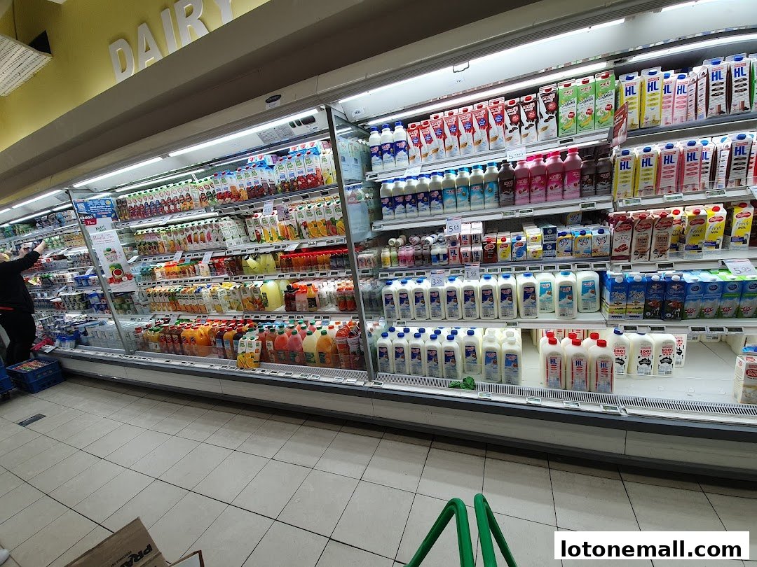 A wide selection of dairy products and juices displayed in a refrigerated aisle.