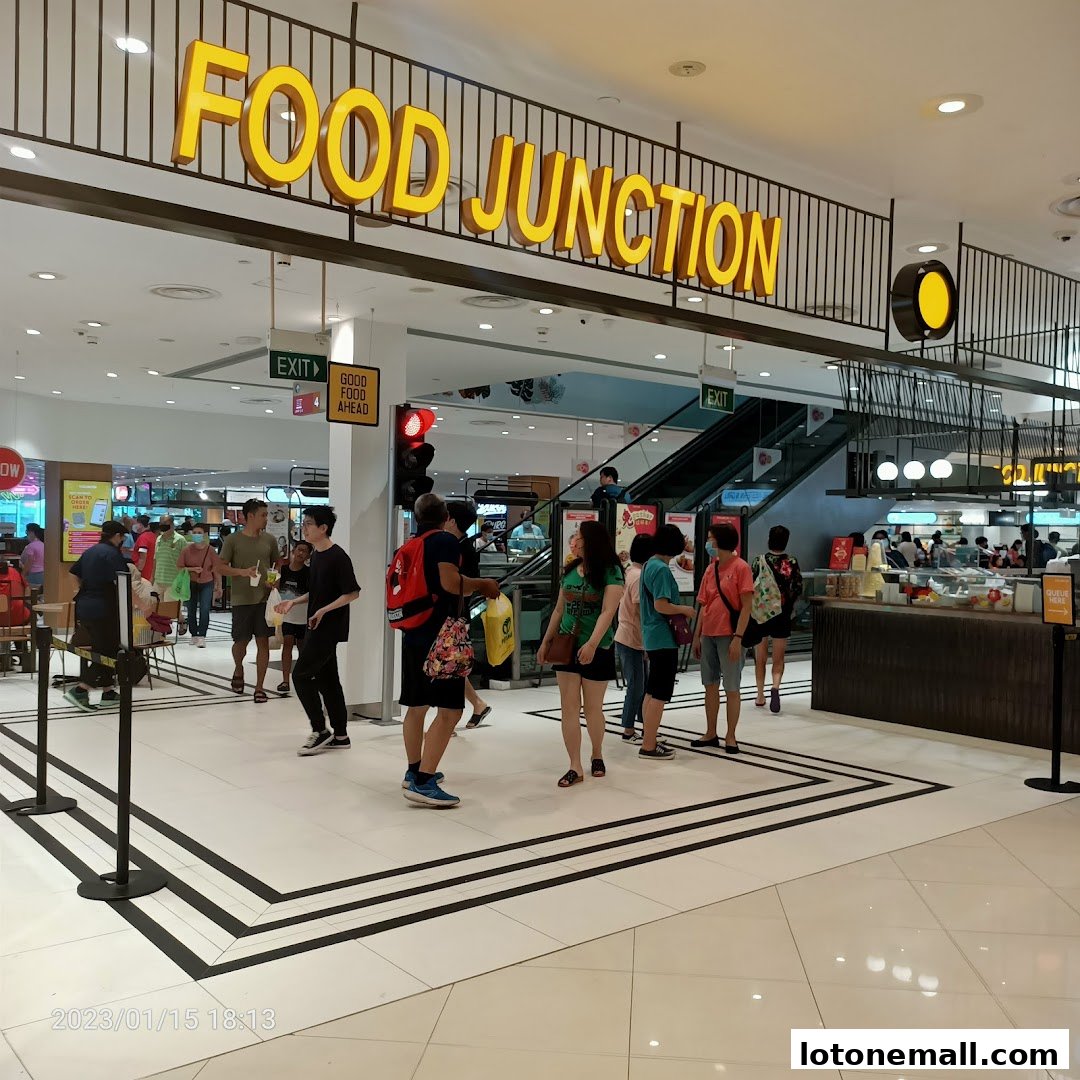 People walking towards a busy food court with a large 'FOOD JUNCTION' sign.