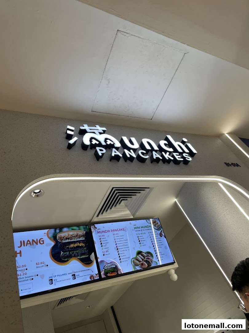 Digital menu boards displaying various pancake options and fillings at Munchi Pancakes.
