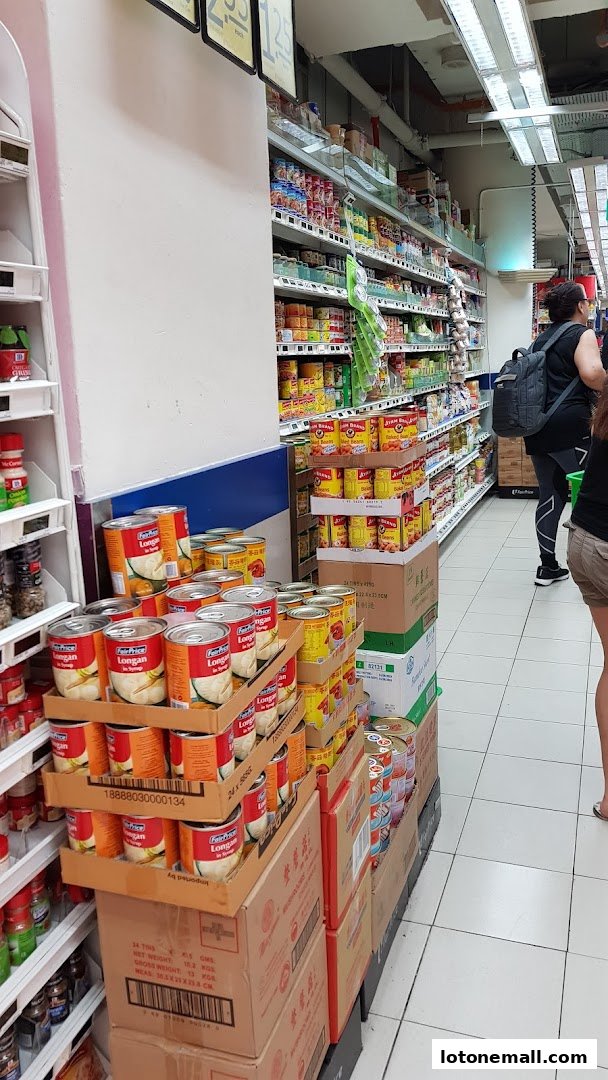 Aisle in a supermarket with shelves stocked with canned goods and other products.