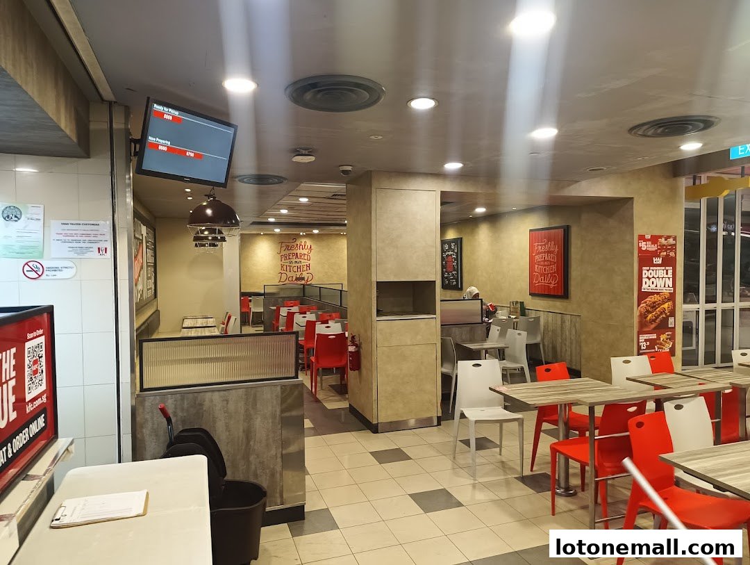 Interior view of a KFC restaurant with tables, chairs, and promotional posters.