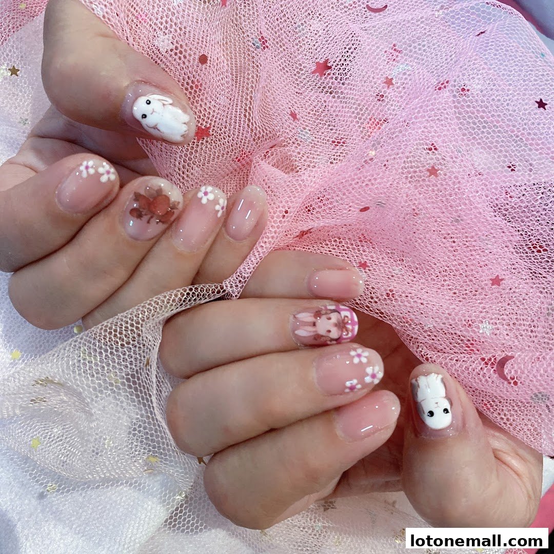 Close-up of hands with intricate nail art featuring bunnies and flowers.
