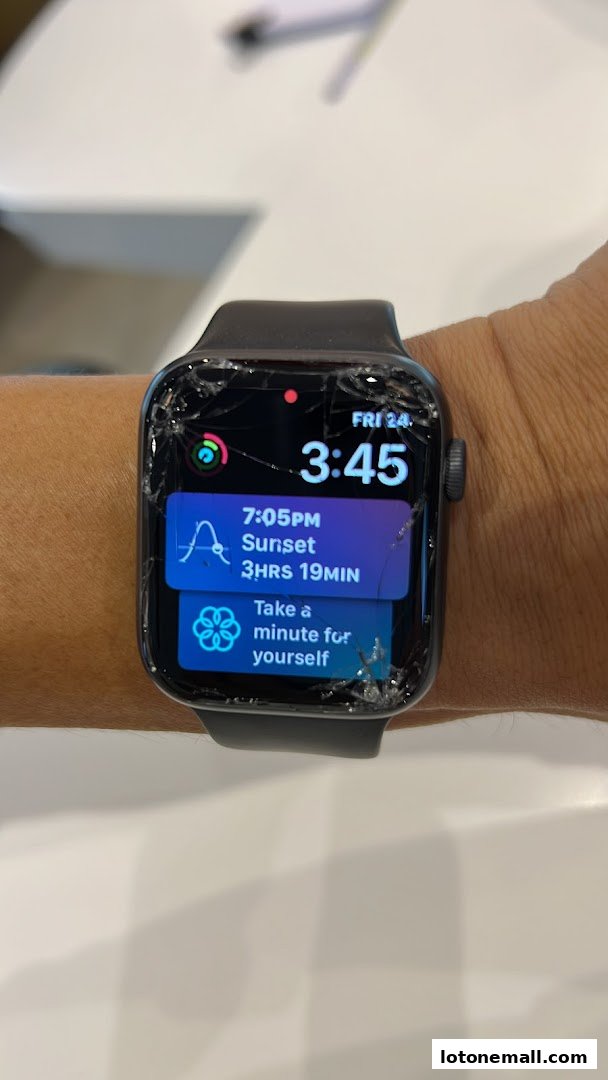 A cracked Apple Watch displaying time, sunset information, and a mindfulness reminder.