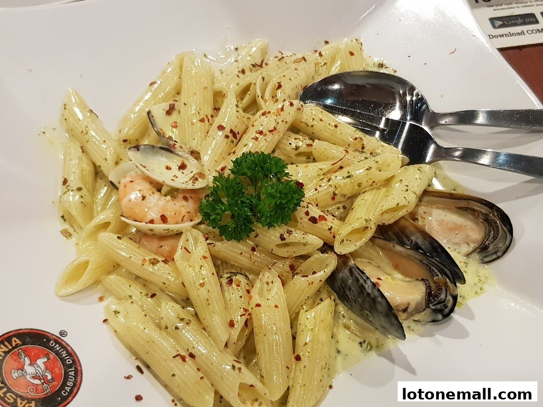 A plate of penne pasta with seafood, garnished with parsley and chili flakes.