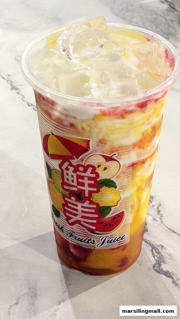 A vibrant, layered fruit juice drink with ice in a clear cup, featuring a 'Fresh Fruits Juice' label.