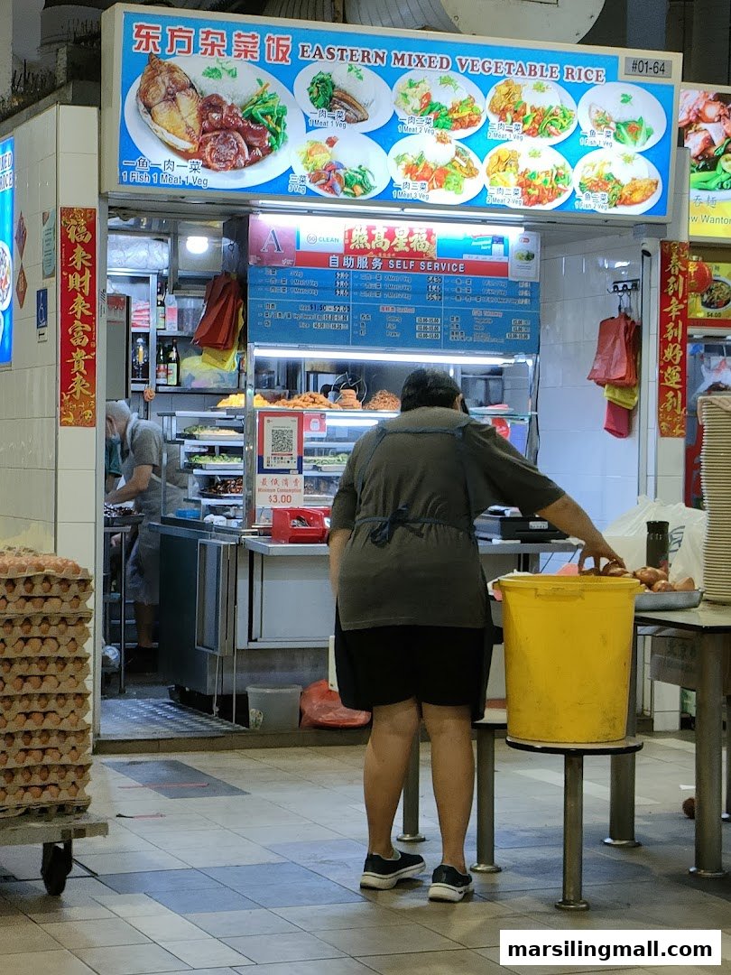 A bustling food stall named 'Eastern Mixed Vegetable Rice' with a prominent signboard and staff.