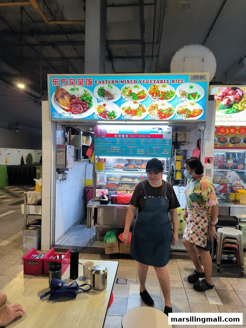 The front of Eastern Mixed Vegetable Rice stall, featuring its main signboard, food display, and staff.