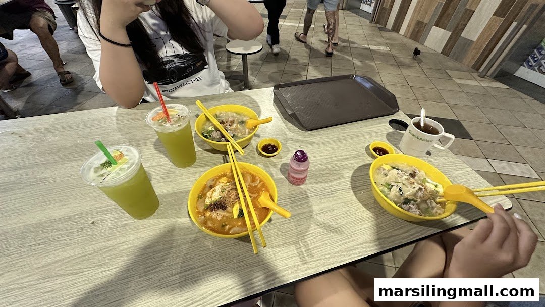A table with multiple bowls of noodles/soup and drinks, suggesting a casual dining experience.