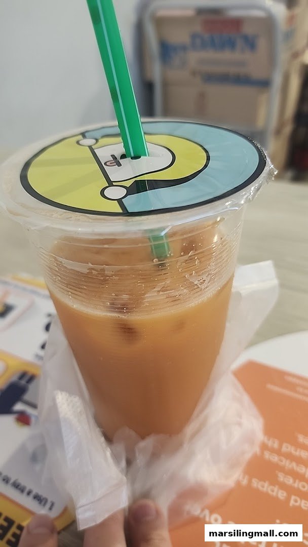 A refreshing iced drink with a green straw and a unique baseball-themed lid design.