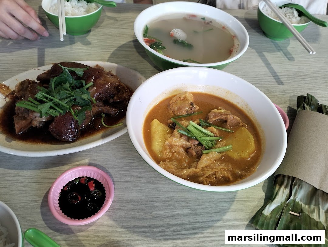 A table laden with delicious Asian dishes including braised pork, curry, soup, and rice.