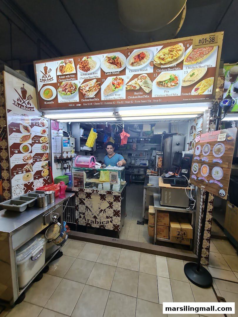 An Arabica Kebab food stall with a large menu board displaying various Middle Eastern dishes.
