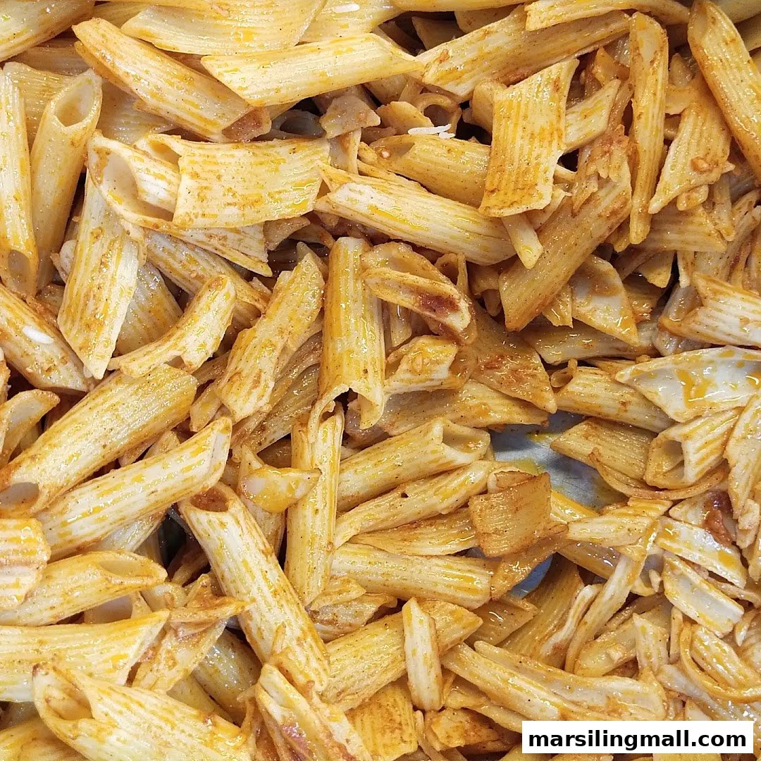 A close-up view of seasoned penne pasta, ready to be served.