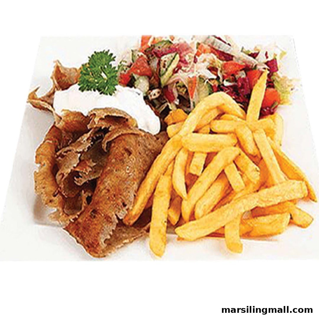 A plate of kebab meat with french fries, fresh salad, and a dollop of sauce.