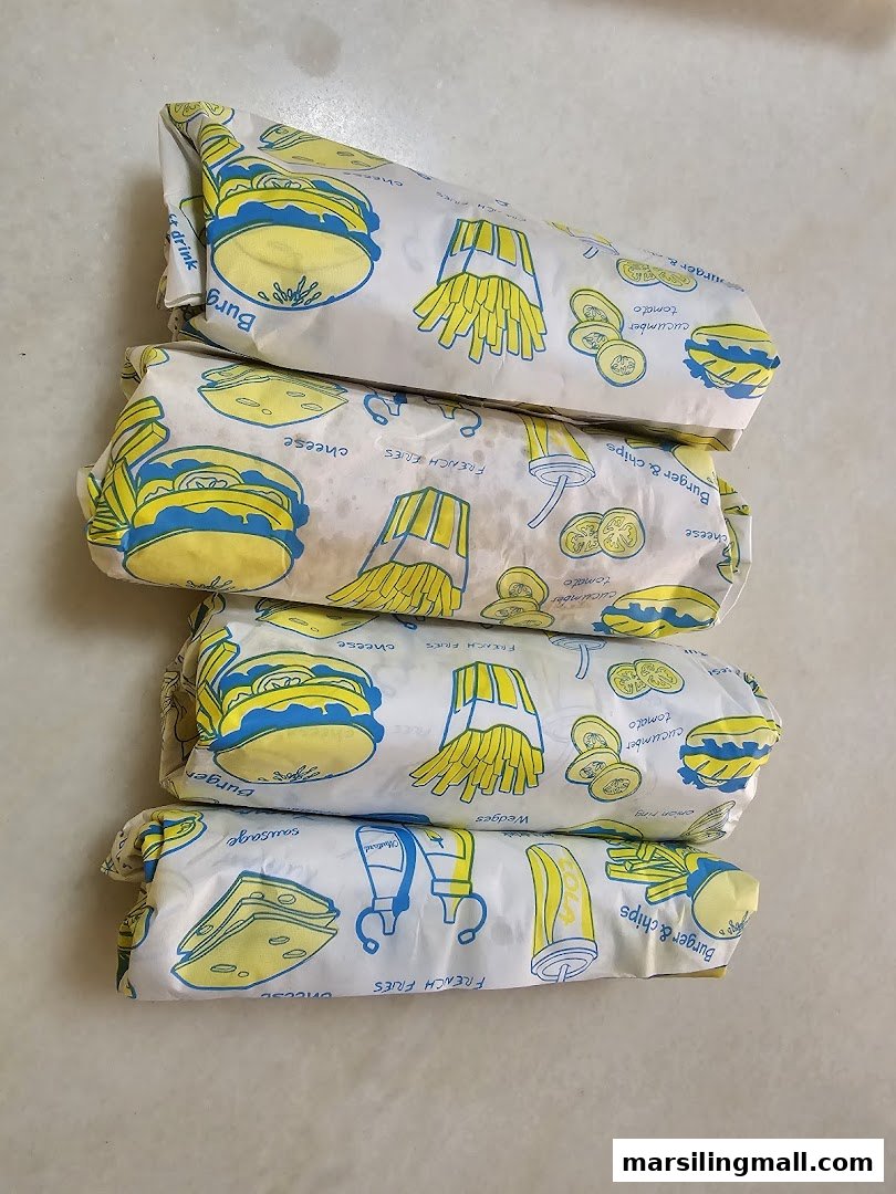 Four wrapped food items with burger, fries, and vegetable illustrations on the packaging.