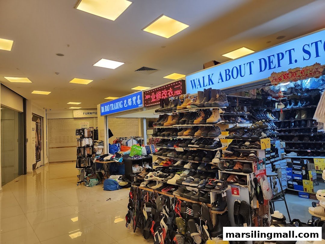 A mall interior showcasing various retail displays, including shoes and clothing, along a brightly lit walkway.