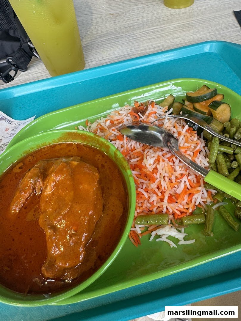 A vibrant plate of chicken curry, colorful biryani rice, and fresh vegetables.