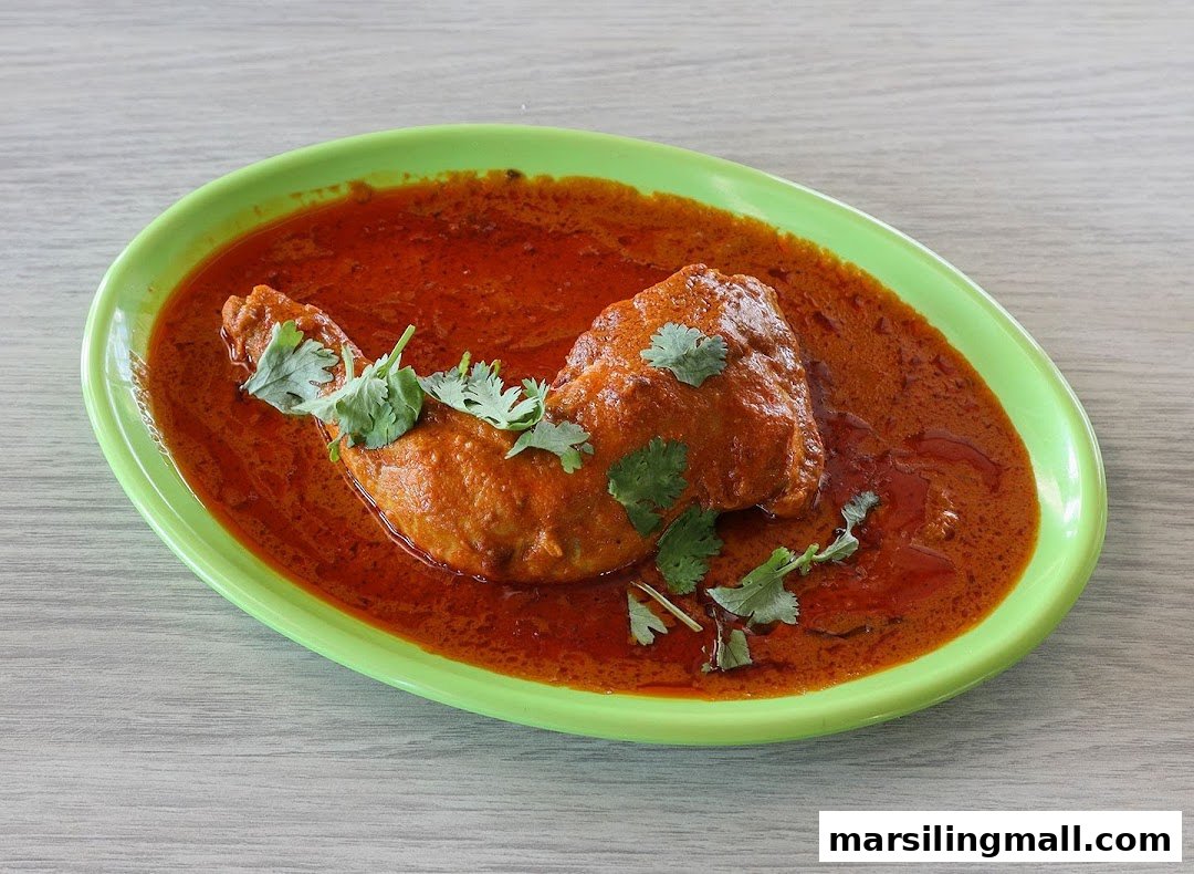 Vibrant chicken curry garnished with fresh cilantro on a bright green plate.